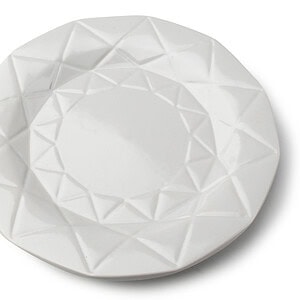 Delikatny biały talerz ceramiczny z geometrycznym wzorem na brzegu, idealny do serwowania potraw i dekoracji stołu.