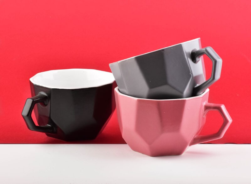Nowoczesne filiżanki ceramiczne w czerni, szarości i różu, idealne do kawy i herbaty, stylowe i funkcjonalne naczynia do domu i biura, nawiązujące do trendów kuchennych.