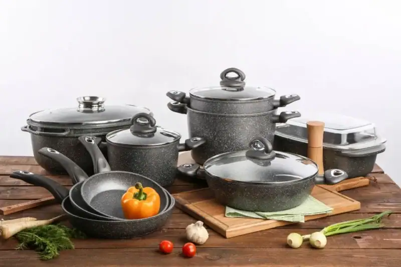 Nowoczesny zestaw garnków ceramicznych i stalowych na drewnianym stole, idealny do kuchni w domu i na co dzień, wysokiej jakości naczynia kuchenne domowy zakątek.