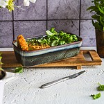 OkiŚwietny kuszący wygląd świeżych ziół w ceramicznym naczyniu na drewnianej desce, otoczonych kwiatami i zielenią, na tle szarej ściany, w klimacie kuchni domowej, naturalnej i zdrowej.