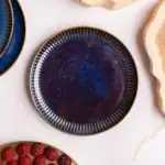 Elegancka, ręcznie wykonana porcelanowa miska w głębokim odcieniu niebieskiego z delikatnym złotym zdobieniem, idealna na eleganckie serwowanie dań i dekorację wnętrz w domu.