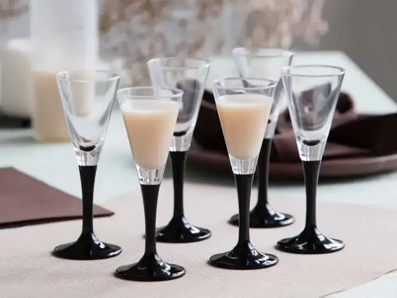 Krówki z likierem podane w eleganckich kieliszkach na specjalną okazję, idealne do domowych imprez i spotkań rodzinnych, luksusowe słodycze na bazie alkoholu w stylowym otoczeniu.
